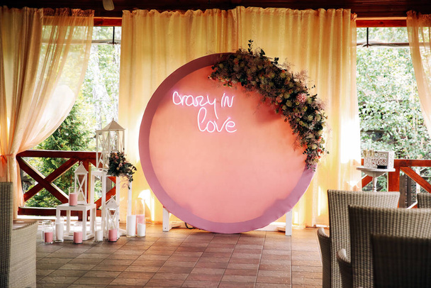 Kiev / Ukraine - 06/09/2019 - Wedding decor. Beautiful circular arch with natural flowers in pink shades on a background of yellow curtains   - Photo, Image