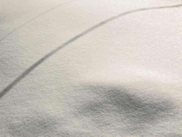 Árnyékok, minták és vonalak a hó felszínén. Textúra. Háttér. Fekete, fehér - Fotó, kép