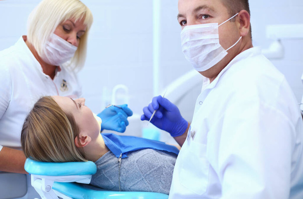 Retrato de un dentista que trata los dientes de una paciente joven - Foto, Imagen