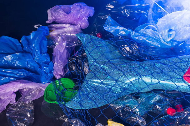 海洋プラスチック汚染。人魚のプラスチックごみと水の中で泳ぐのクローズアップ。プラスチック汚染を止めなさい。おとぎ話と現実の概念. - 写真・画像