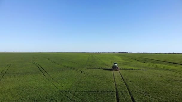 Maatilojen koneet ruiskuttamalla hyönteismyrkkyjä vihreälle pellolle, maatalouden luonnollinen vuodenaikojen kevät toimii. - Materiaali, video