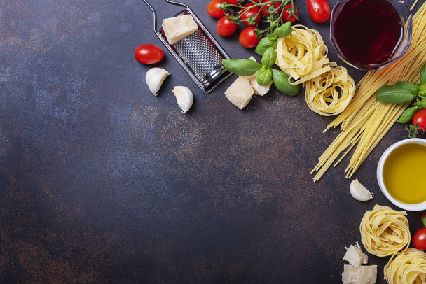 Top view image with a copy space of spaghetti, tagliatelle, tomato, basil, cheese, garlic and wine. Concept of a healthy Italian cooking - Zdjęcie, obraz