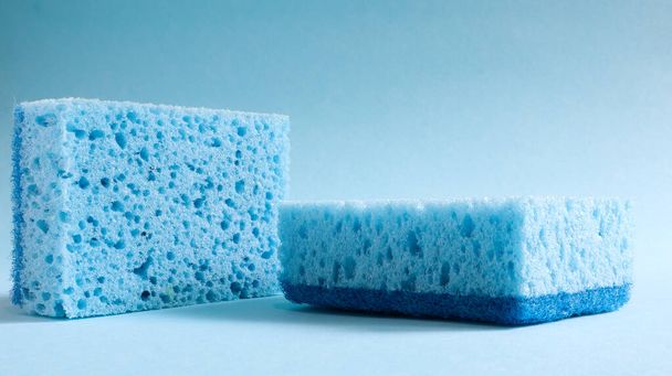 Deux éponges bleues utilisées pour laver et effacer la saleté utilisée par les femmes au foyer dans la vie quotidienne. Ils sont faits de matériaux poreux tels que la mousse. Rétention de détergent, qui vous permet de le dépenser économiquement
. - Photo, image