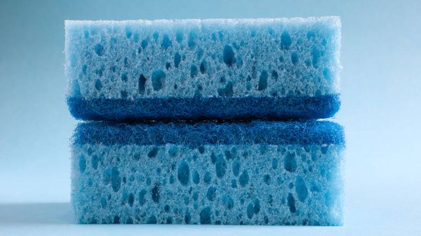 Deux éponges bleues utilisées pour laver et effacer la saleté utilisée par les femmes au foyer dans la vie quotidienne. Ils sont faits de matériaux poreux tels que la mousse. Rétention de détergent, qui vous permet de le dépenser économiquement
. - Photo, image