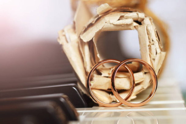 Dva zlaté snubní prsteny a staré hudební noty, klavírní klávesy - Fotografie, Obrázek