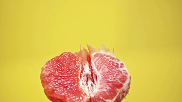 drops falling on ripe grapefruit isolated on yellow - Filmagem, Vídeo