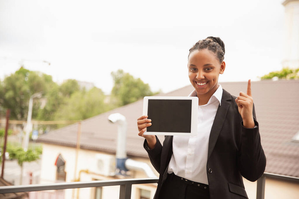 African-american businesswoman in office attire smiling, looks confident and happy, successful - Foto, Imagen