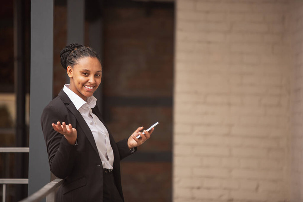 African-american businesswoman in office attire smiling, looks confident and happy, successful - Фото, зображення