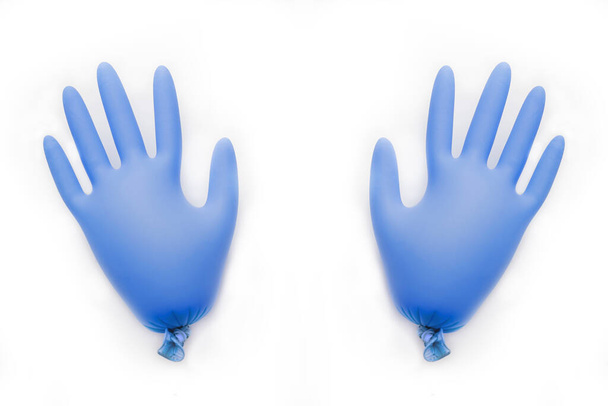 Сині гумові рукавички з повітрям всередині лежать на світлому фоні
 - Фото, зображення