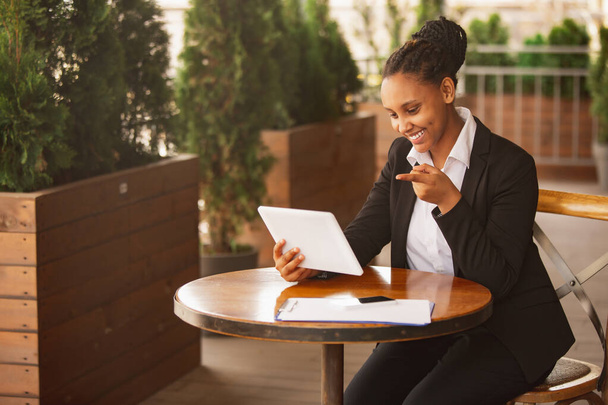 Афроамериканська бізнес-леді в офісі посміхається, виглядає впевненою і щасливою, успішною - Фото, зображення