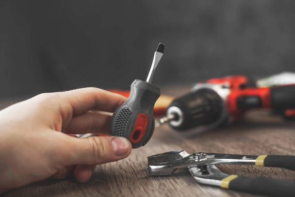 a small screwdriver set among the tools on a wooden table - Fotoğraf, Görsel
