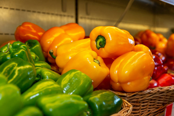 Sweet bell peppers of different colors on a shelf in a store. Close-up. Healthy nutrition and vitamins. - Foto, imagen