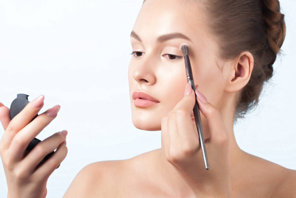 Young woman is applying eye makeup. Beauty, skin care - Foto, Imagen