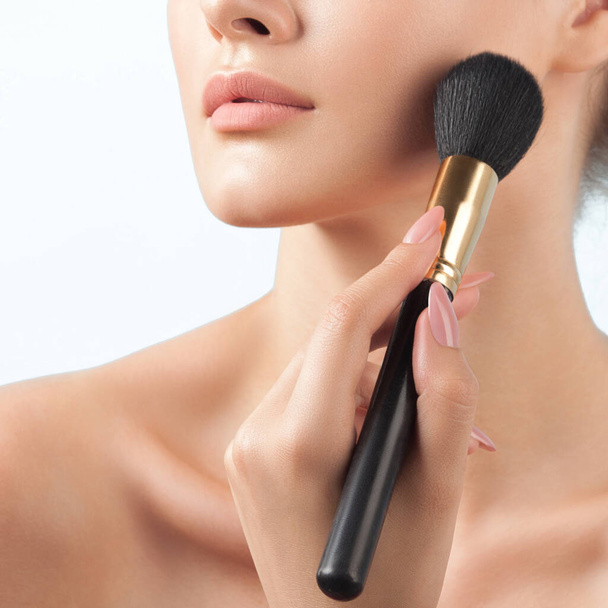 young woman uses makeup brush. Powder, tone and blush. Beauty and skin care - Foto, Imagen