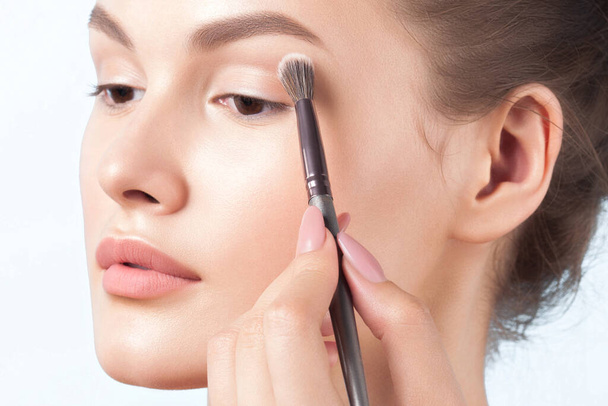 Young woman is applying eye makeup. Beauty, skin care - Фото, зображення