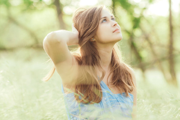 beautiful romantic girl sitting on field of spikelets and enjoying nature, young elegant woman walking - Zdjęcie, obraz