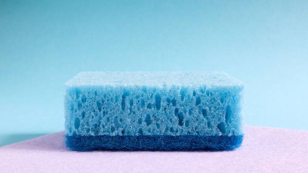 Una esponja azul utilizada para lavar y borrar la suciedad utilizada por las amas de casa en la vida cotidiana. Están hechas de material poroso como espuma. Retención de detergente, que le permite gastarlo económicamente
. - Foto, Imagen