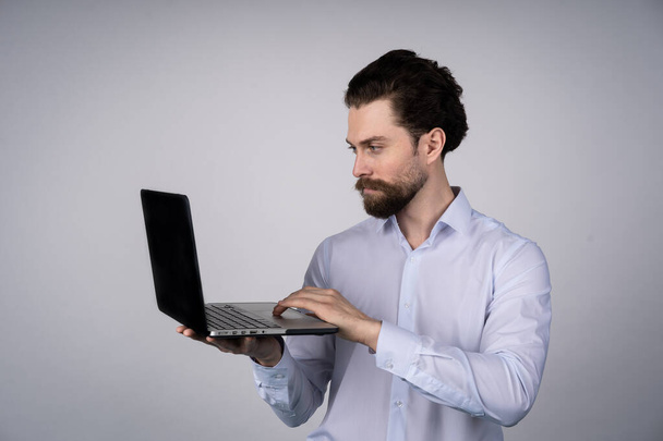 Portrait d'homme, travaillant sur ordinateur portable dans les occasionnels - isolé sur blanc. Communication conceptuelle. - Photo, image