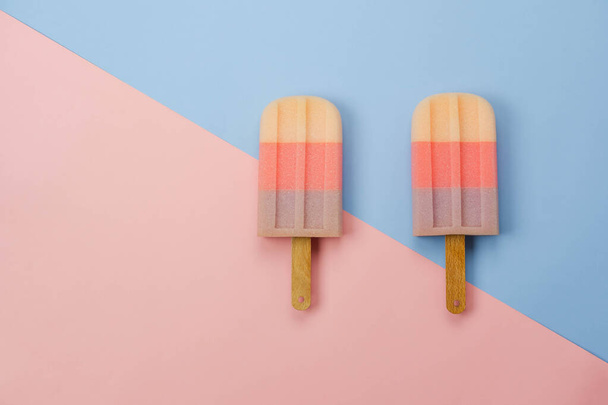 表夏休みの背景コンセプトの看板や食品の空中像。現代素朴なピンクの紙の背景にパステル甘いアイスクリームのフラットレイ。. - 写真・画像