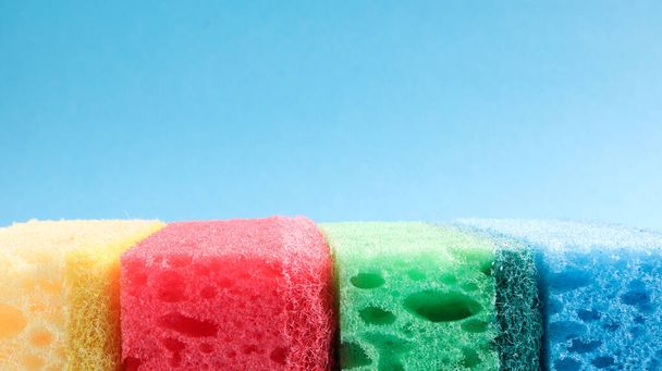 Many blue, red, yellow, green sponges are used to wash and wipe the dirt used by housewives in everyday life. They are made of porous material such as foam. good detergent retention. - Φωτογραφία, εικόνα