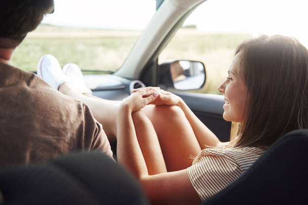 Junge Frau im Auto mit Beinen auf dem Armaturenbrett.  - Foto, Bild