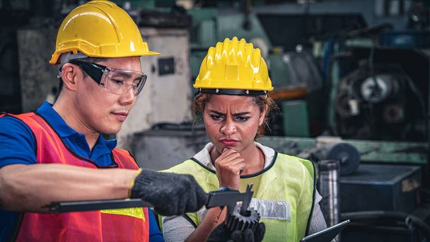Dois trabalhadores industriais multiétnicos discutindo o trabalho na fábrica. Gestão do controlo da qualidade
. - Foto, Imagem