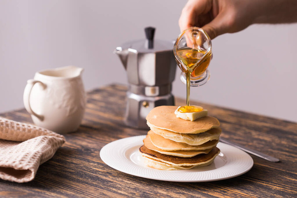 Maple syrup pouring over a stack of mini pancakes. - Foto, immagini