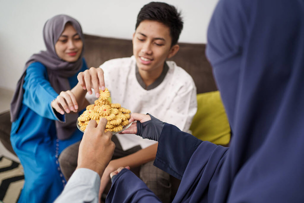 people eating eid mubarak snacks - Foto, afbeelding