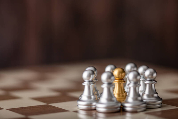 scacchista d'oro in piedi in mezzo a bordo con sfondo in legno
 - Foto, immagini
