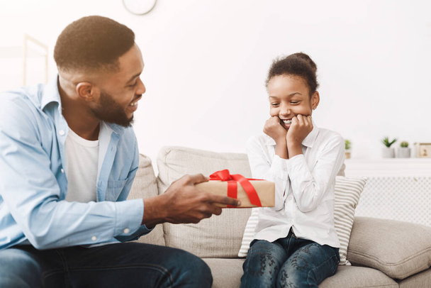 Африканский отец дарит подарок на день рождения дочери
 - Фото, изображение