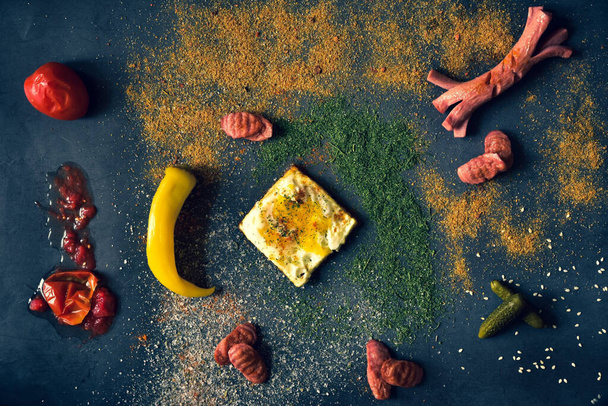 gegrilde worsten, paprika en kaas op donkere achtergrond - Foto, afbeelding