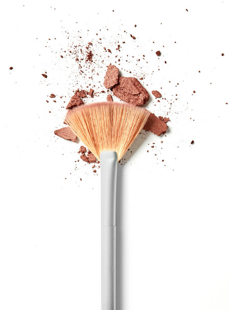 Make-up borstel en verbrijzelde roze oogschaduw geïsoleerd op wit - Foto, afbeelding
