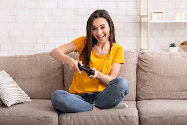Home entertainment. Happy lady with joystick playing online computer games indoors - 写真・画像