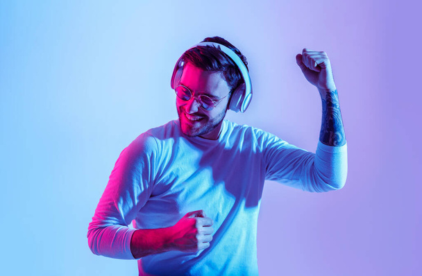 Dancing to favorite music. Guy with headphones has fun with favorite song - Fotoğraf, Görsel
