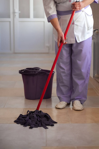 A nurse mops the floor in a hospital - Photo, Image