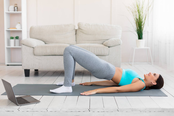 Fitness Woman Doing Pilates Exercise At Laptop During Home Training - Foto, Imagen