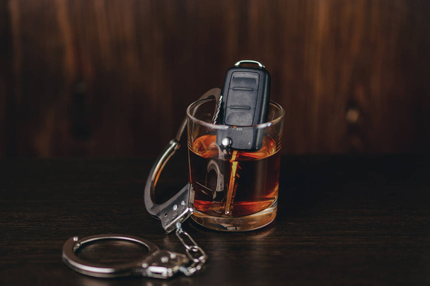 Whisky s klíčky od auta a želízka. Koncept pro pití a řízení motorových vozidel - Fotografie, Obrázek