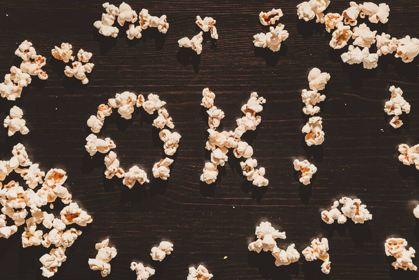 Der Satz "OK!" wird aus Popcorn auf einem Holztisch ausgebreitet - Foto, Bild