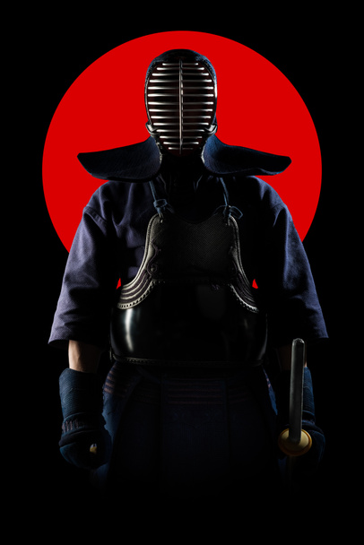 Male in tradition kendo armor with Samurai sword katana on red moon and black background. (unrecognizable person, dark mask) Shot in studio. Isolated with clipping path. - Foto, afbeelding