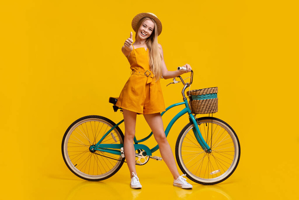 Екологічний транспорт. Дівчина стоїть поруч з вінтажний велосипед і показуючи великий палець вгору
 - Фото, зображення