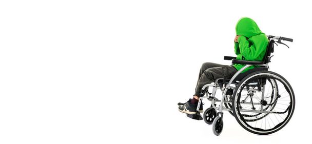 Мальчик в инвалидной коляске на белом фоне, мальчик сидит в инвалидной коляске на белом фоне. Больничный пациент с ограниченными возможностями
 - Фото, изображение