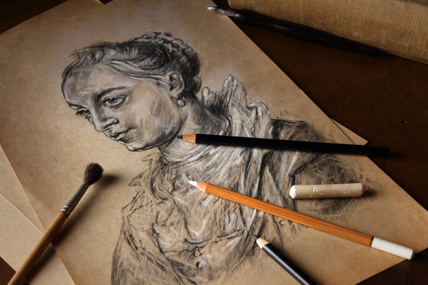 Pencils, brush and white pastel on the background of a copy of a female portrait in retro style - Foto, Bild