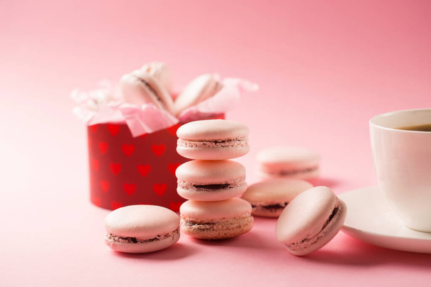 Morning cup of coffee, cake macaroons, gift or present box on pink background. Beautiful breakfast. Holiday time concept. - Foto, Imagem