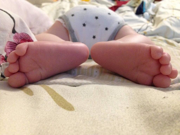 два дитячі підбори в різних напрямках, перші фото новонароджених. дитячі п'яткові ноги
. - Фото, зображення