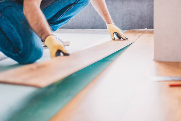 The builder is engaged in laying laminate in the room - repair and finishing work - Foto, Imagem