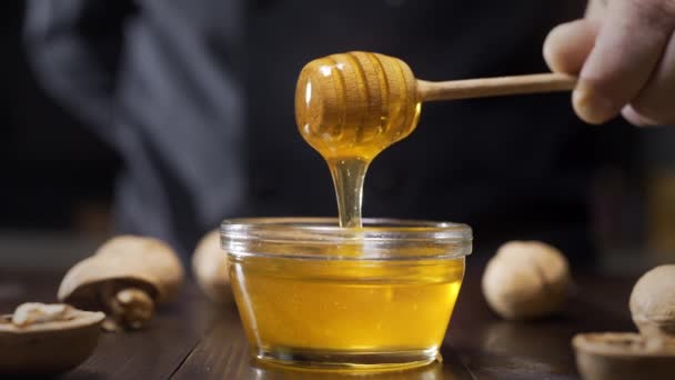 chef sumerge palo de miel de madera en el tazón de vidrio
 - Imágenes, Vídeo