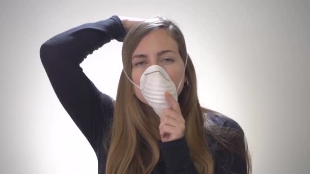 Coronavirus concept. COVID-19. Young woman with protection mask on white background. STOP the virus concept slow motion. Isolated at home. warned confinement. Social distancing. Flu. - Filmagem, Vídeo