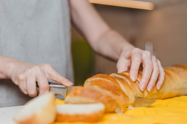 Fresh baked baguette bread on wooden cutting board - making sandwiches - Foto, Bild