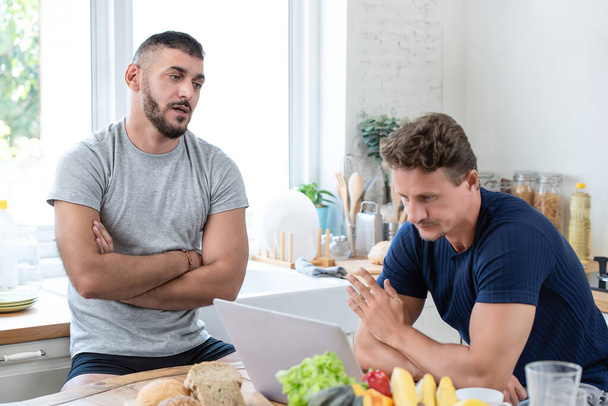 Mature caucasian gay male couple having an arguement while having breakfast in the morning at home - Photo, Image