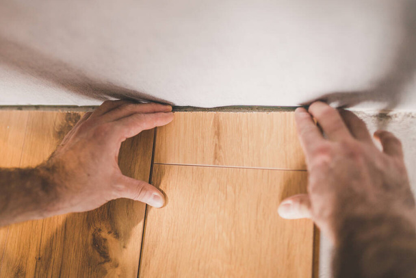The builder is engaged in laying laminate in the room - repair and finishing work - 写真・画像